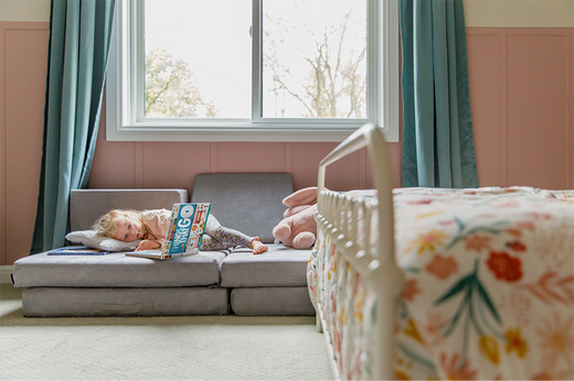 Child looking at a book to learn when to start potty training