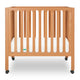 Modern wooden crib on wheels with visible mattress, isolated on a white background. 999-8430-CST