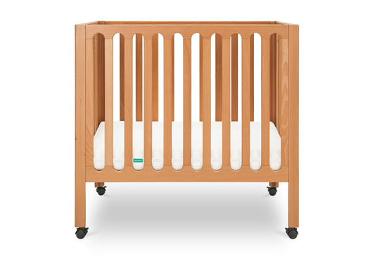 Modern wooden crib on wheels with visible mattress, isolated on a white background. 999-8430-CST