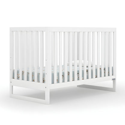 The Austin Convertible Crib by dadada baby is a white, sustainably crafted beechwood 3-in-1 crib with vertical slats and modern design, shown with a light blue Newton crib mattress against a plain white background. 500-8200-WHT