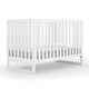 The Austin Convertible Crib by dadada baby is a white, sustainably crafted beechwood 3-in-1 crib with vertical slats and modern design, shown with a light blue Newton crib mattress against a plain white background. 500-8200-WHT