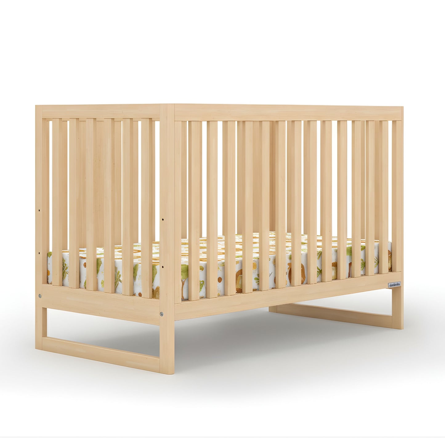 The dadada baby Austin Convertible Crib, made from sustainable beechwood with vertical slats and a colorful patterned mattress, is shown in light wood against a white background.