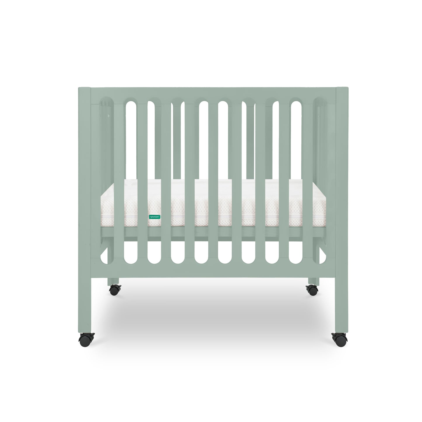 The Newton Galileo Mini Crib with Newton Mattress by Newton Baby is shown in light green with vertical slats, a white mattress, and four black wheels against a plain white background.