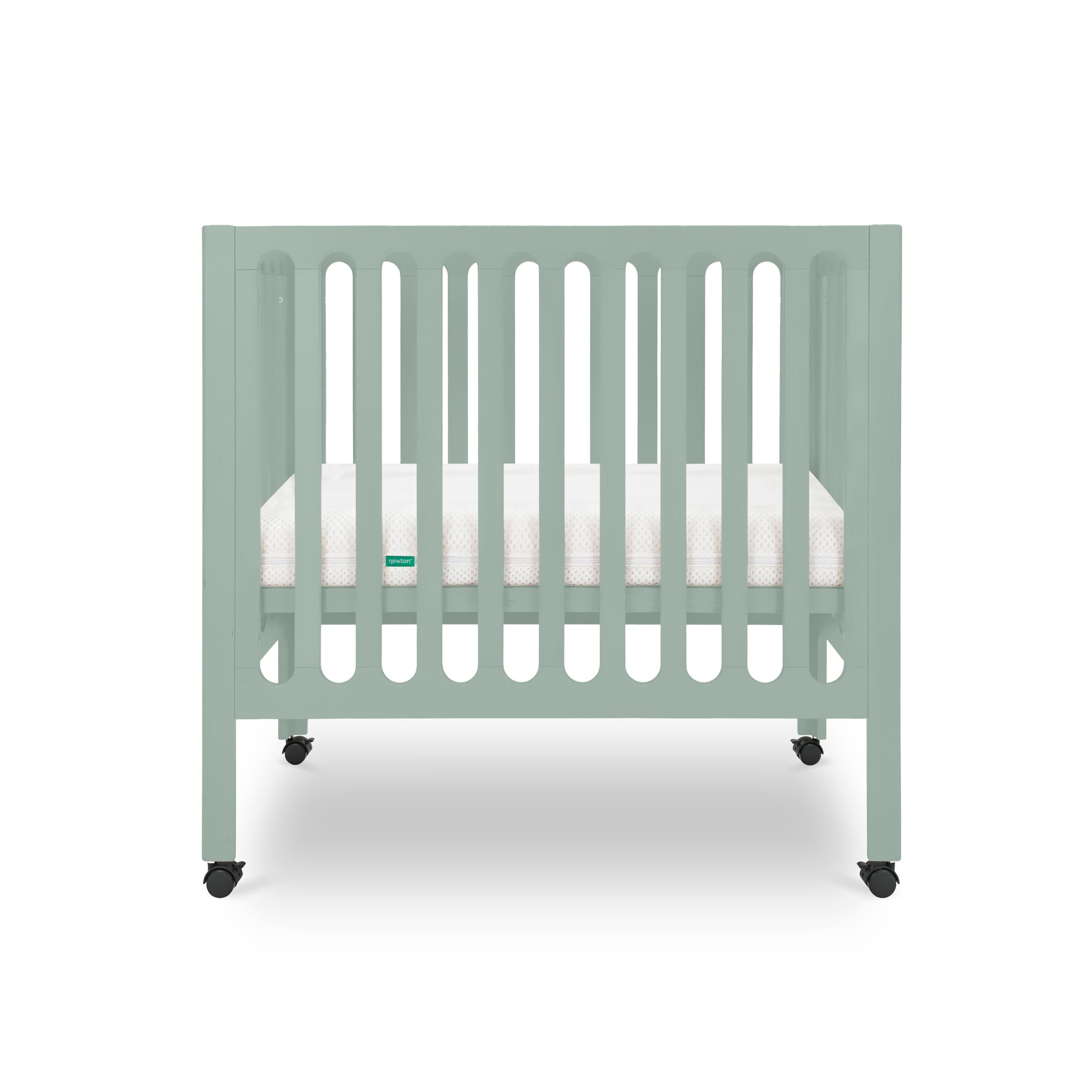 The Newton Galileo Mini Crib with Newton Mattress by Newton Baby is shown in light green with vertical slats, a white mattress, and four black wheels against a plain white background.