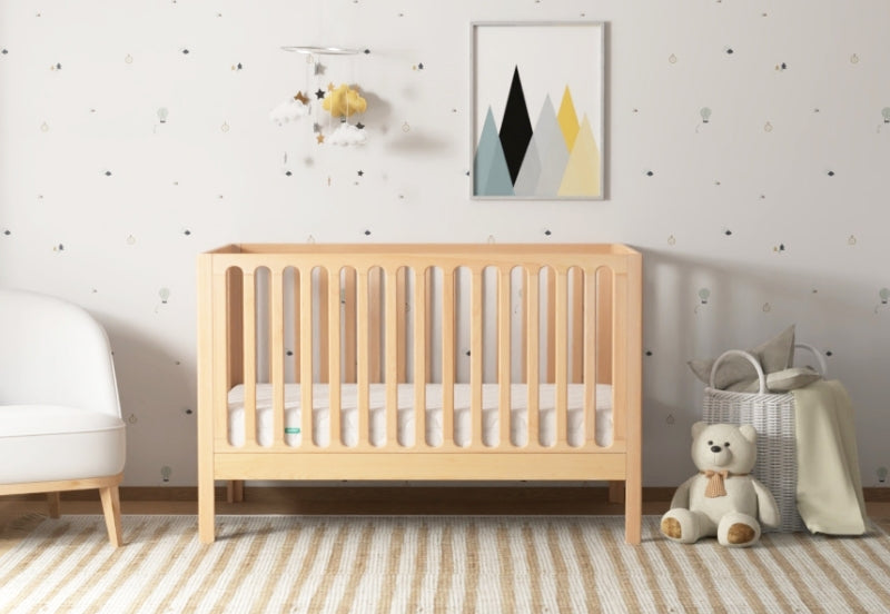 A serene nursery featuring a wooden crib, striped rug, and a plush teddy bear, decorated with a minimalist art piece and a gentle color palette.