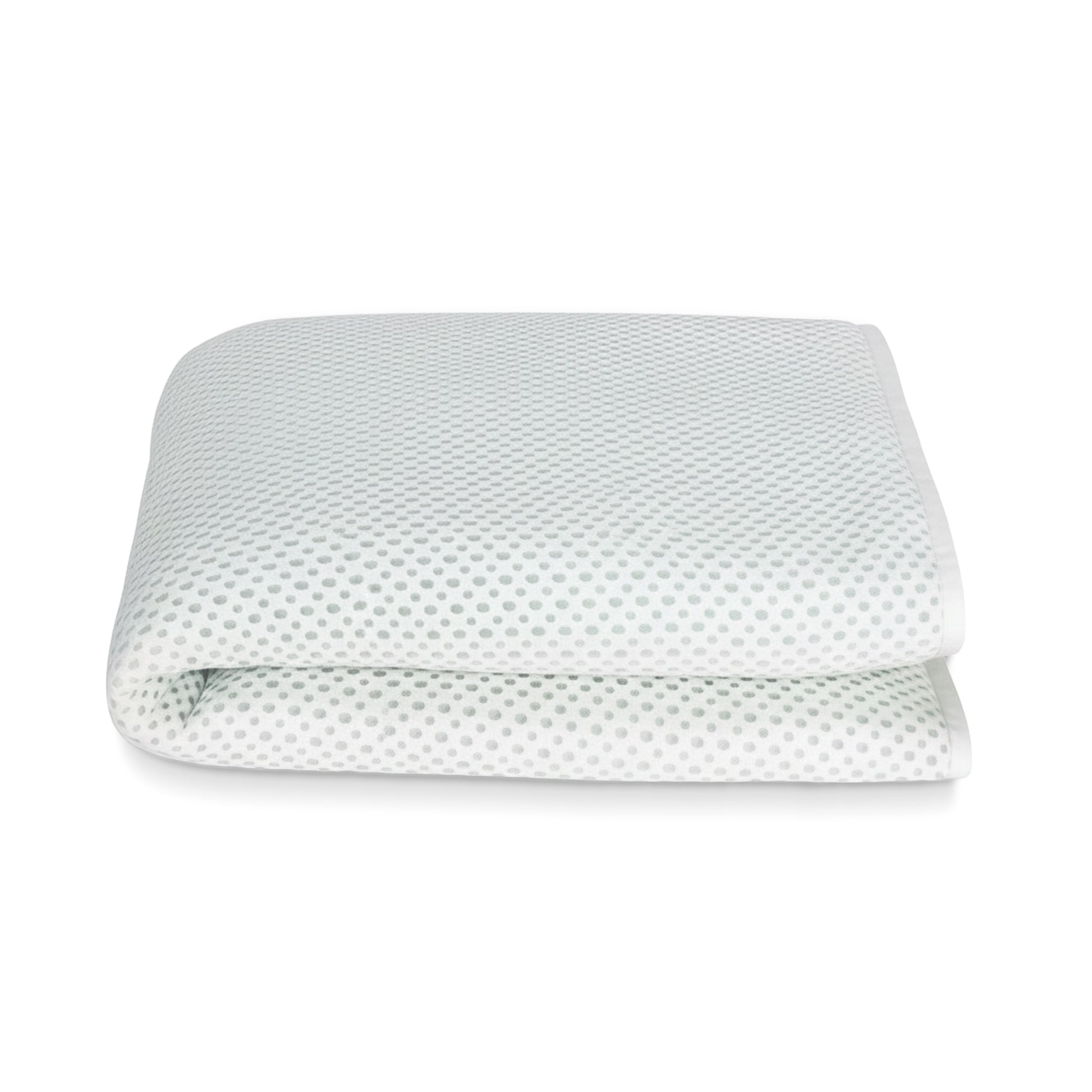 The Newton Baby Essential Waterproof Crib Pad, featuring a white breathable design with subtle gray dots, is shown folded against a plain white background.