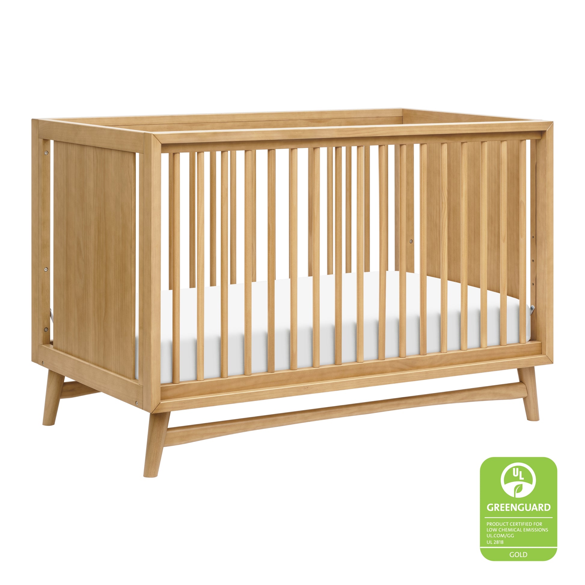 The Babyletto Peggy Convertible Crib features vertical slats on all sides, a white mattress, and angled legs—showcasing subtle mid-century style that's perfect for any modern nursery. 999-8504-HNY
