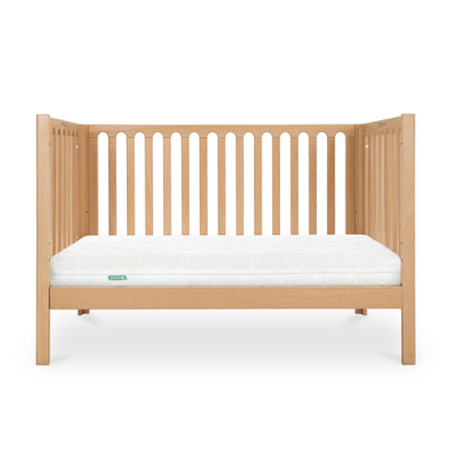 The Newton Baby Newton Galileo Convertible Crib features a natural light beech wood finish, vertical slats, simple modern design, and includes a white mattress. Easily converts to a toddler bed and is pictured against a plain white background.