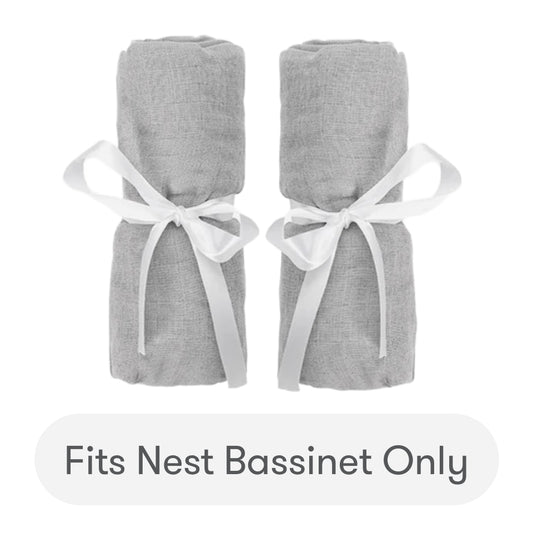 Two rolled gray Newton Baby Nest Bassinet Extra Sheets, tied with white ribbons and placed side by side. Text below reads: Fits Nest Bassinet Only. skip