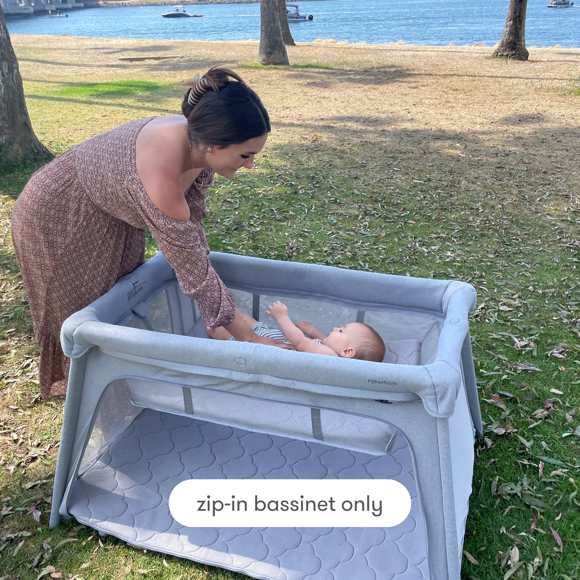 Mother placing baby in bassinet insert outdoors, with text, "zip-in bassinet only", Bassinet Only