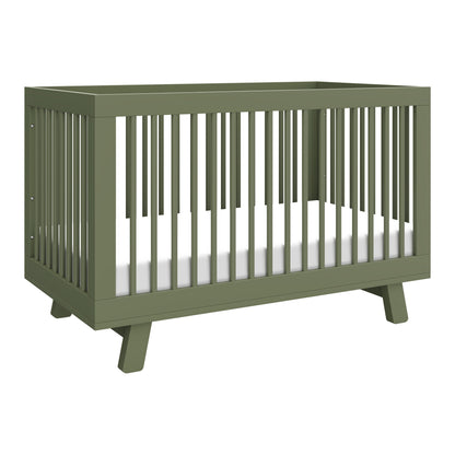 The Babyletto Hudson Convertible Crib in olive green features slatted sides, angled legs, a clean modern design, and a white mattress. It easily converts into a toddler bed for added versatility.