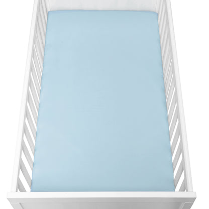 A white baby crib with vertical slats features a Newton Baby Breathable, Organic Cotton Sheet from the 2-pack, in light blue, covering the mattress and viewed from above.