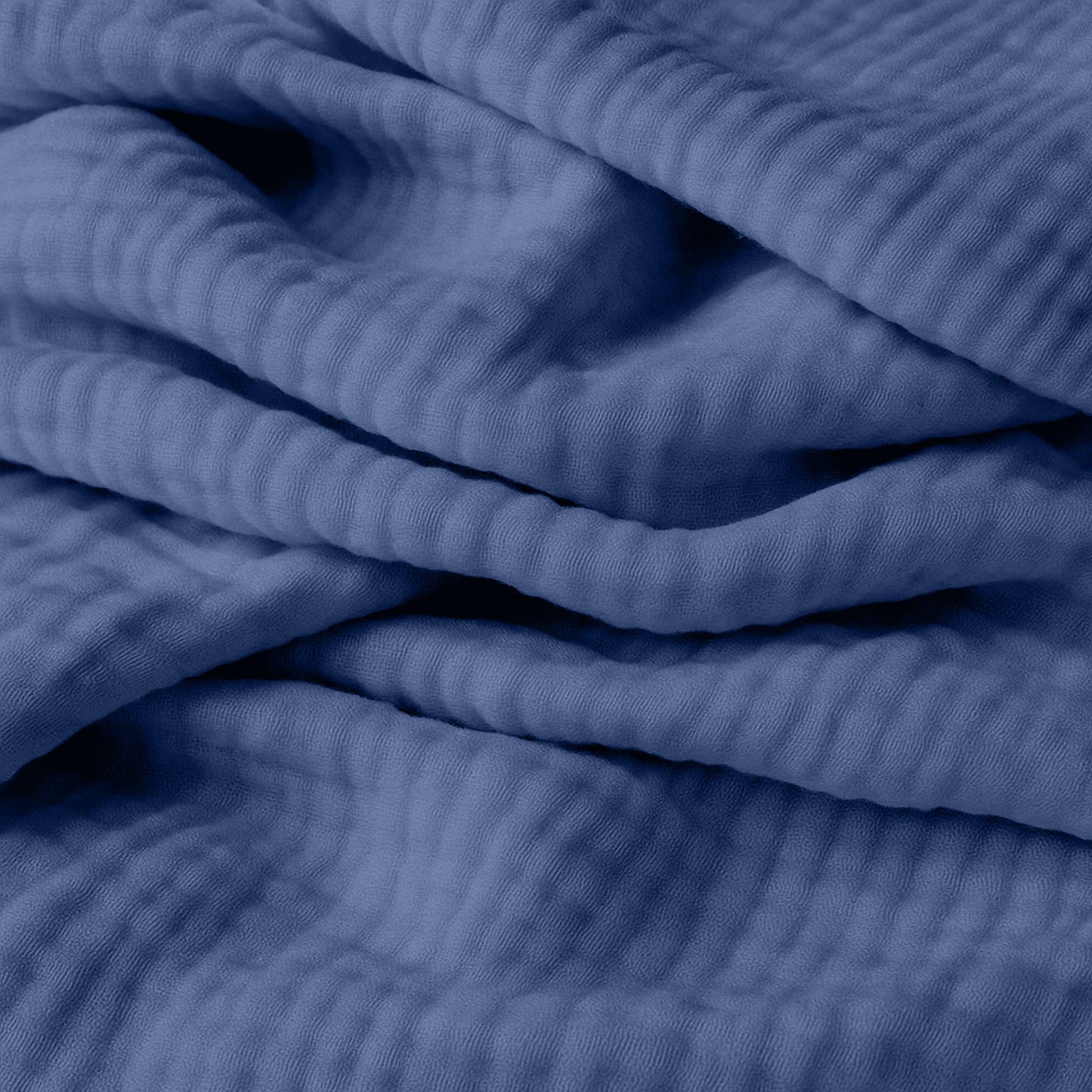 Close-up of breathable, organic cotton fabric from Newton Baby's 2-pack sheets, featuring gentle folds and textured ridges—perfect for adding comfort and depth to your little one's crib.