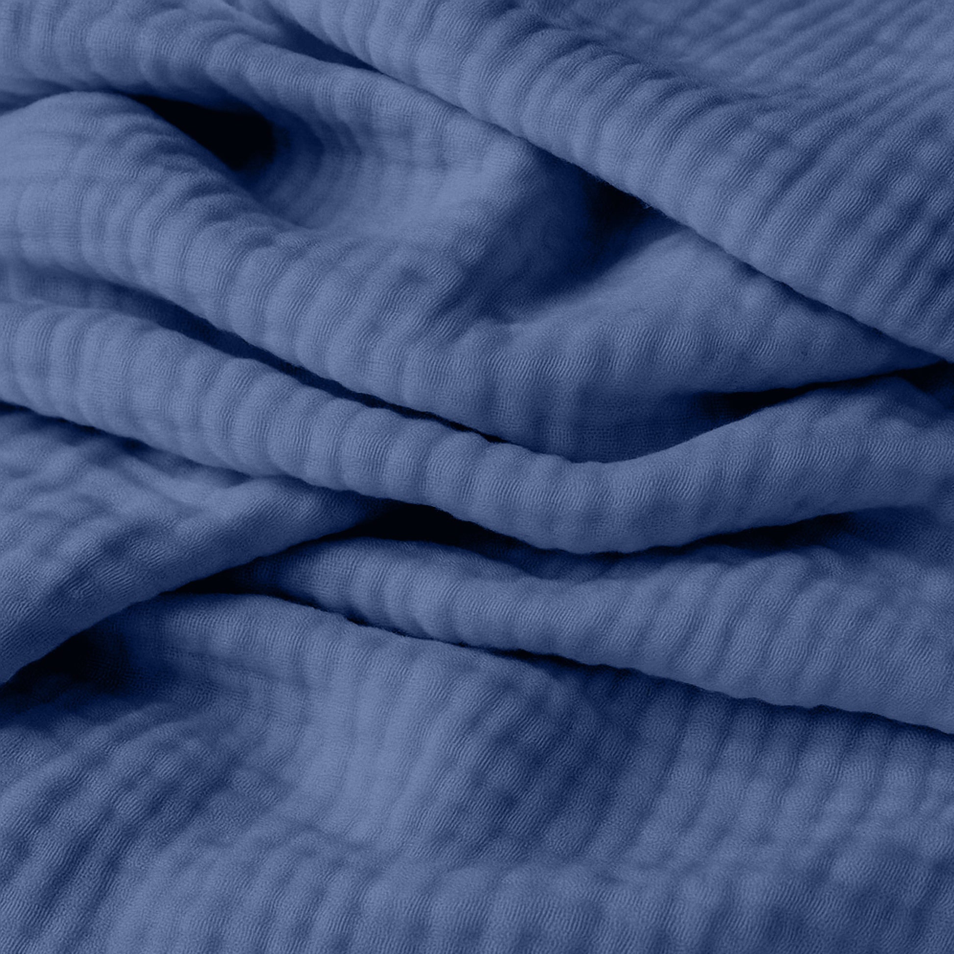 Close-up of breathable, organic cotton fabric from Newton Baby's 2-pack sheets, featuring gentle folds and textured ridges—perfect for adding comfort and depth to your little one's crib.