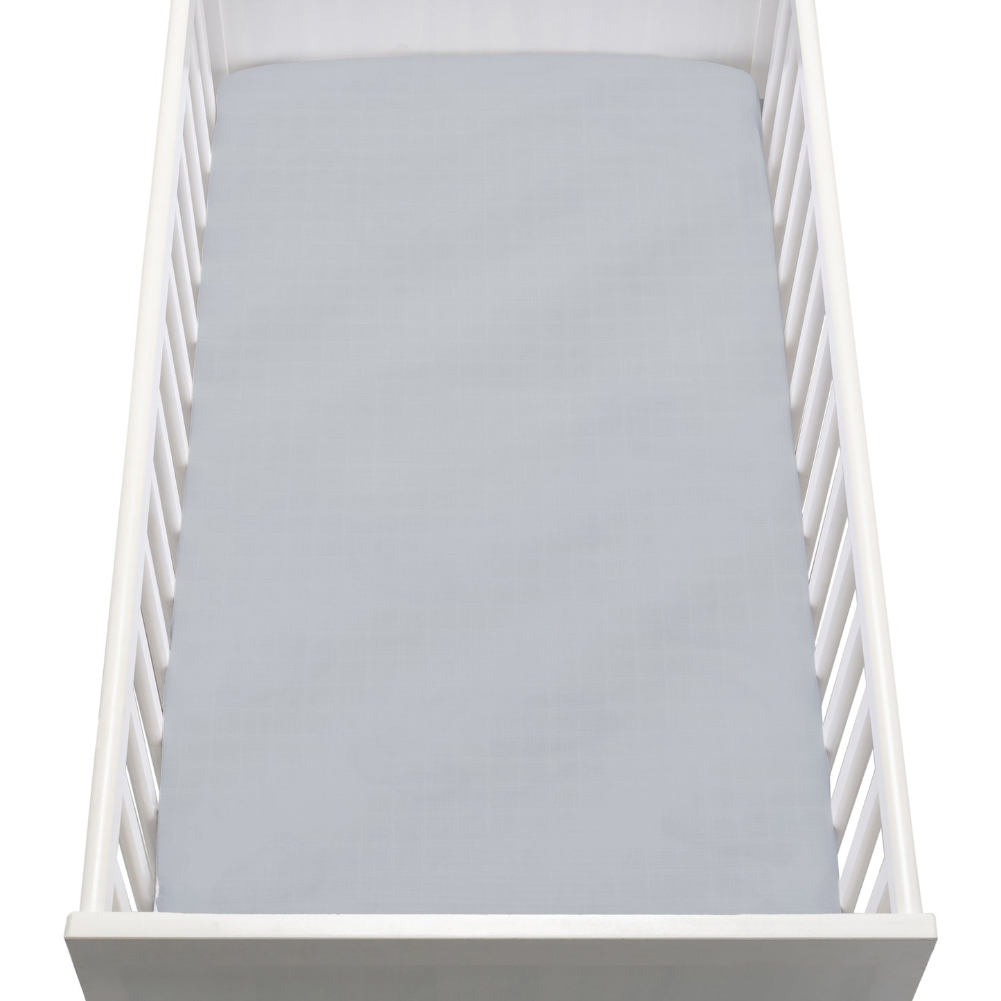 A white baby crib with vertical slats features a Newton Baby Breathable, Organic Cotton Sheet (2-pack) in light gray covering the mattress, viewed from above.
