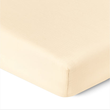 Close-up of a corner of Newton Baby Breathable, Organic Cotton Sheets (2-pack) on a mattress, showing the smooth, tightly-fitted fabric and clean edges.