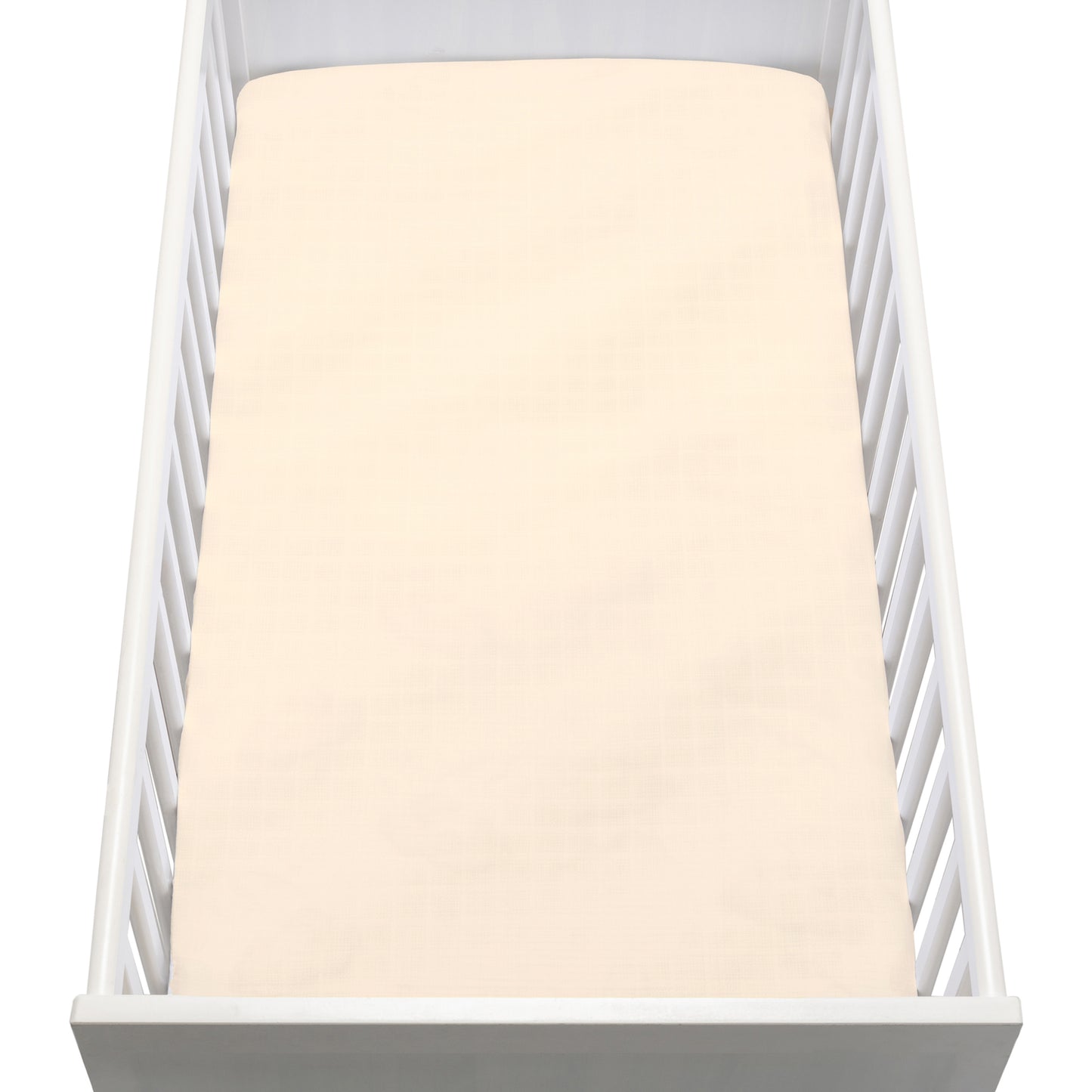 A white baby crib with vertical slats is shown from above, featuring a neatly made mattress covered with Newton Baby Breathable, Organic Cotton Sheets (2-pack) in pale cream. The crib is empty.