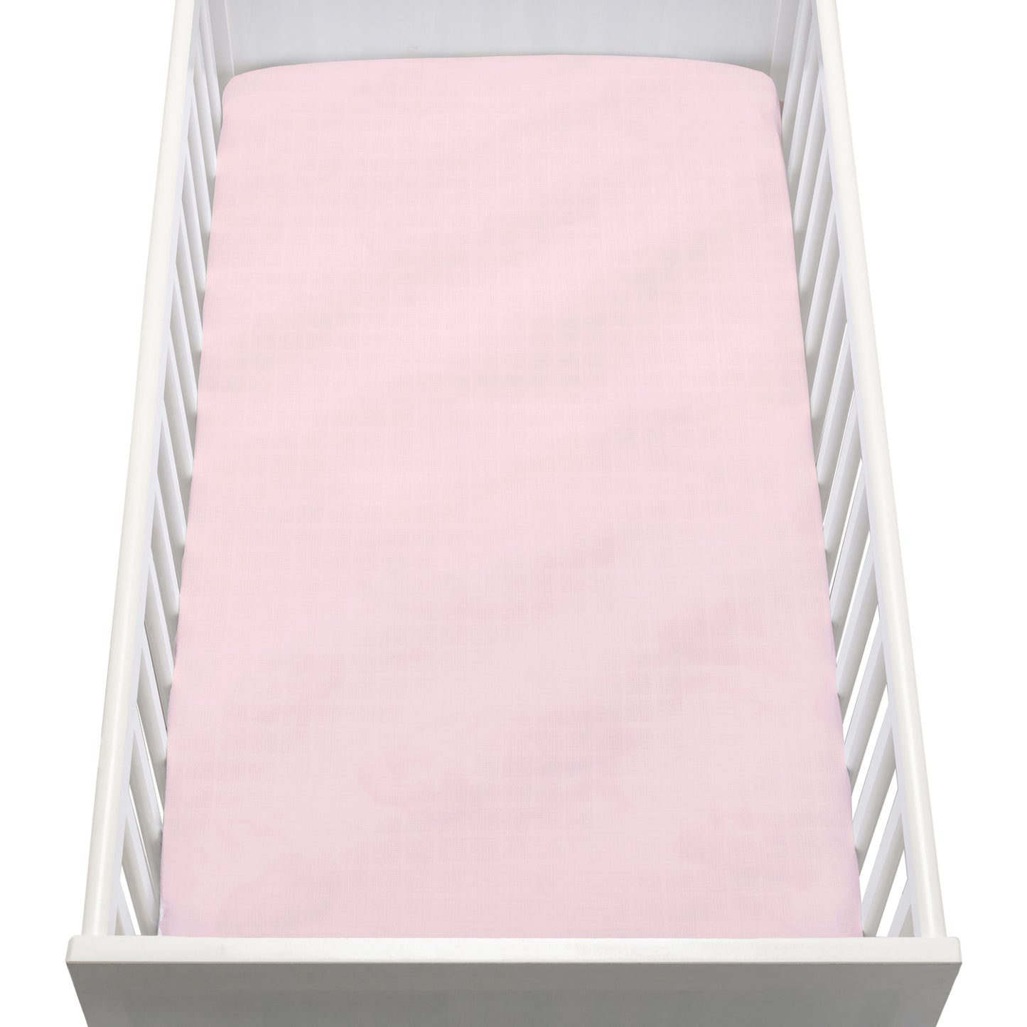 A white crib with vertical slats is seen from above, featuring a Newton Baby Breathable, Organic Cotton Sheet (2-pack) in pale pink, neatly fitted on the mattress.