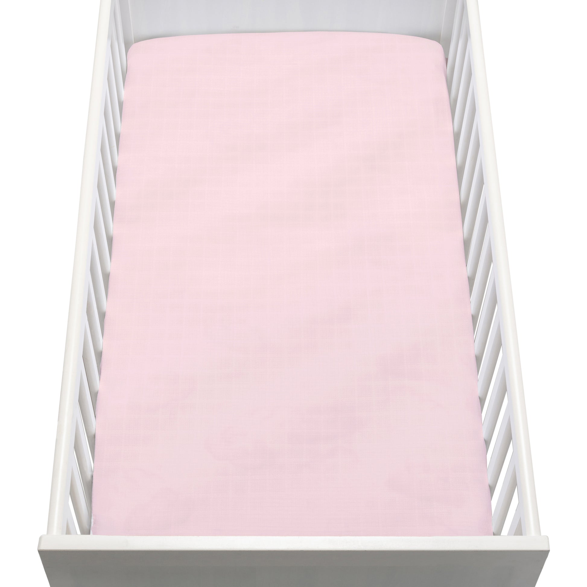 A white crib with vertical slats is seen from above, featuring a Newton Baby Breathable, Organic Cotton Sheet (2-pack) in pale pink, neatly fitted on the mattress.