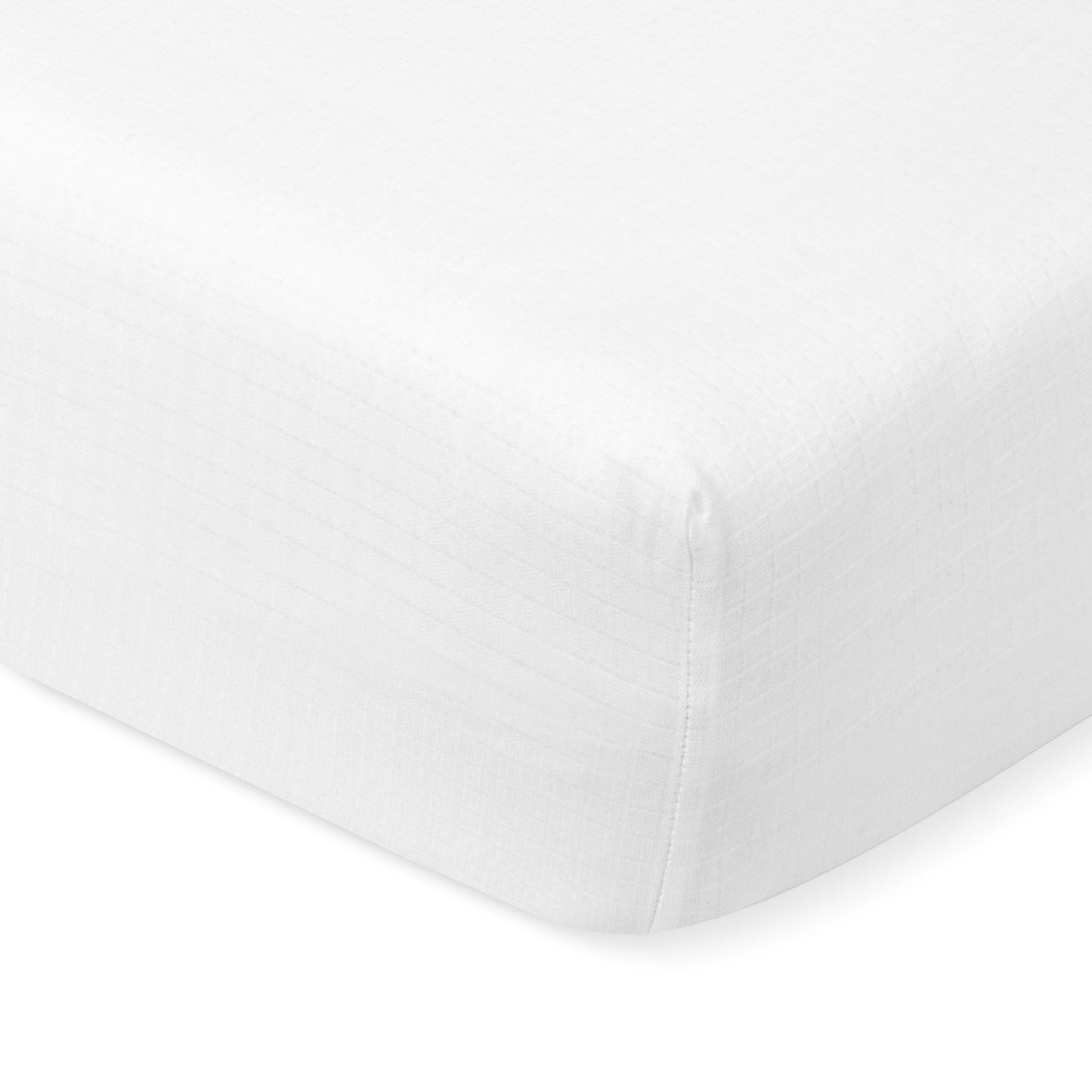 Close-up of a white, fitted Newton Baby Breathable, Organic Cotton Sheet (2-pack) with a subtle checkered pattern, tightly stretched over the corner of a crib mattress.