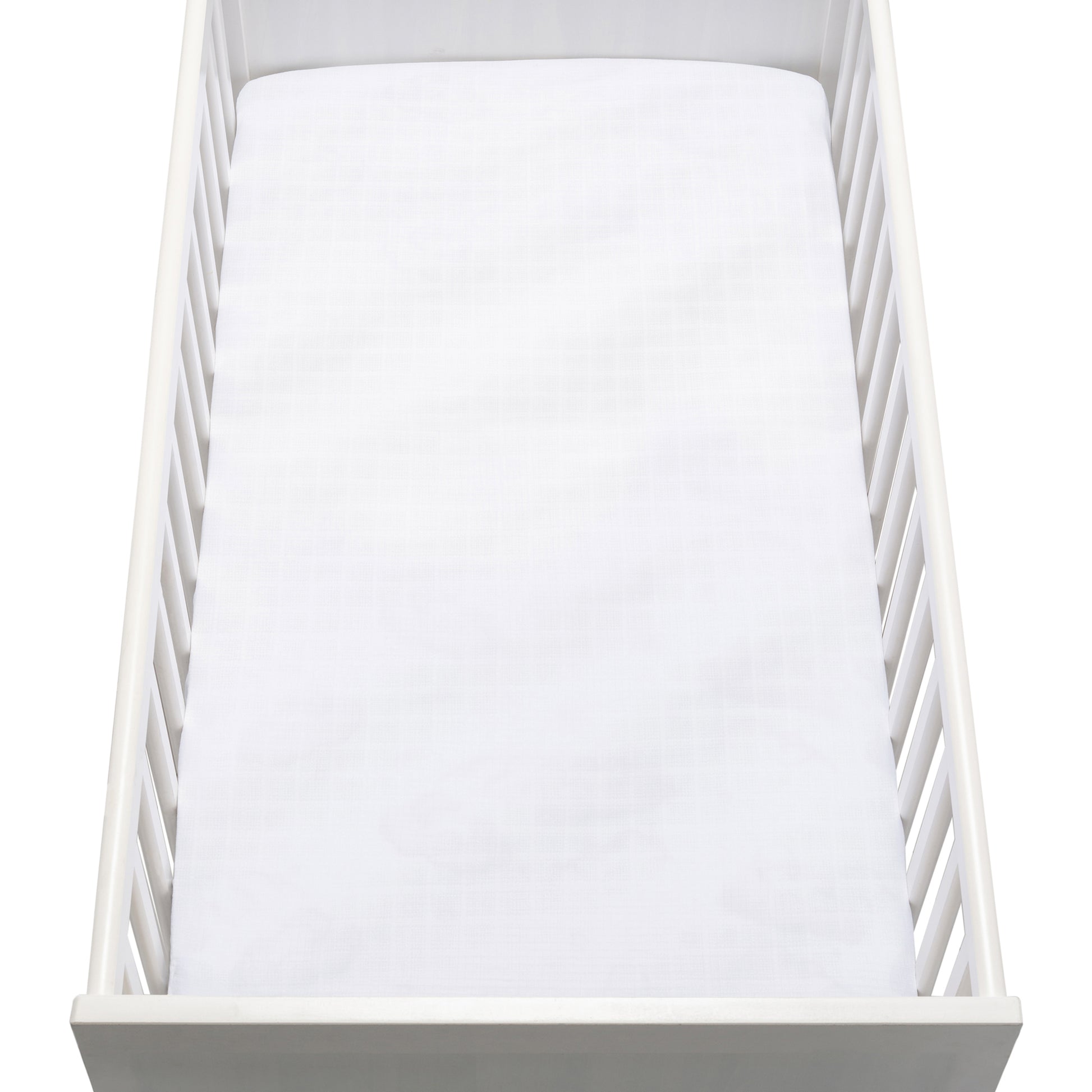 A white crib with vertical slats and a plain mattress is topped with Newton Baby’s Breathable, Organic Cotton Sheets (2-pack), as seen from above.