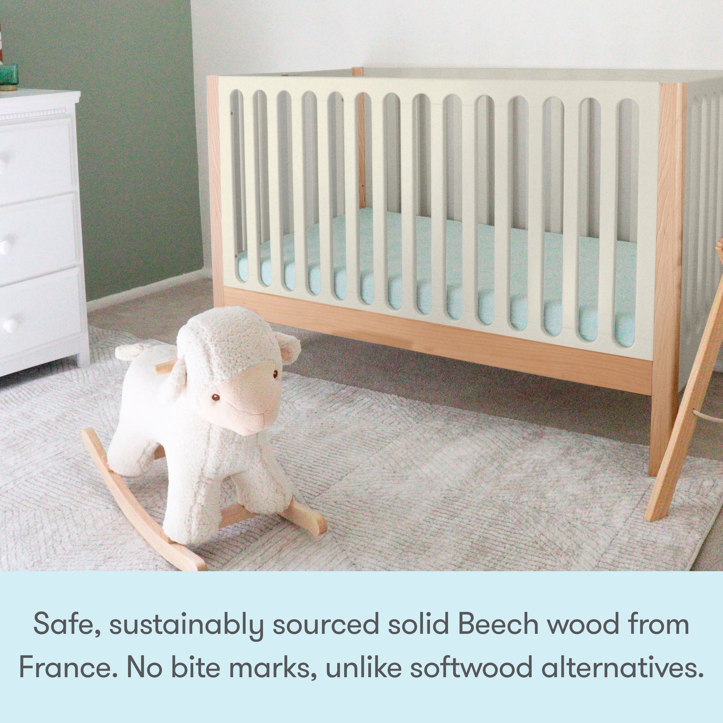 A modern nursery with the Newton Galileo Convertible Crib by Newton Baby, crafted from solid beech wood for safety and durability, plus a white rocking sheep toy. The crib includes a toddler bed conversion kit for growing families.