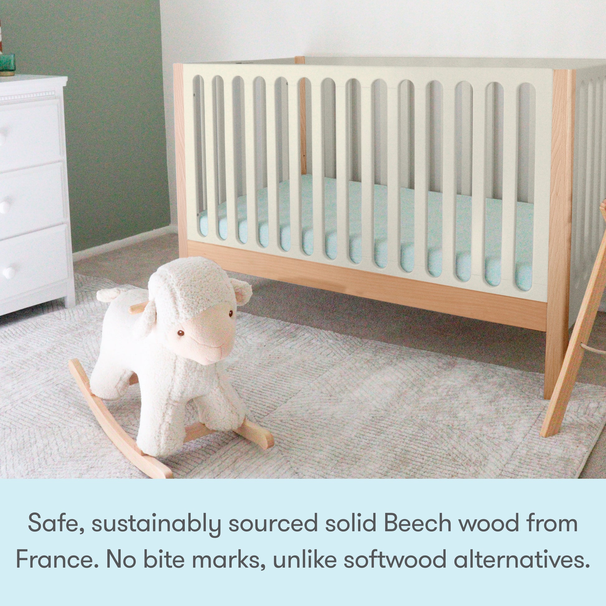 A modern nursery with the Newton Galileo Convertible Crib by Newton Baby, crafted from solid beech wood for safety and durability, plus a white rocking sheep toy. The crib includes a toddler bed conversion kit for growing families.