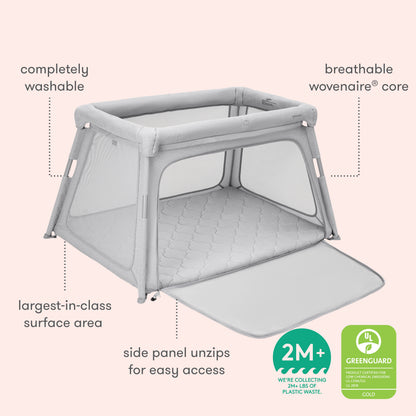 The Newton Baby Deluxe Travel Crib & Play Yard features light gray mesh sides, a zippered panel, and a breathable mattress. It boasts washable fabric, a woven core, large area, GREENGUARD Gold certification, and suits ages 2 months+.