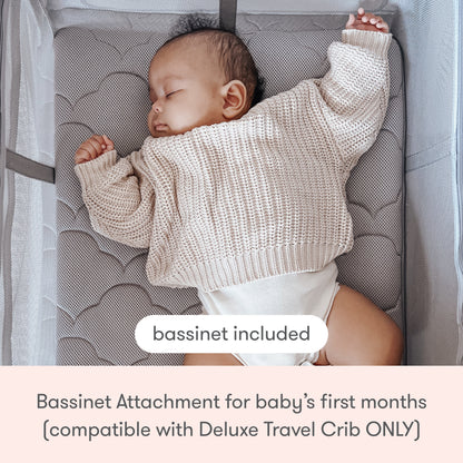 A baby sleeps on a padded, breathable mattress in the Newton Baby Deluxe Travel Crib & Play Yard with included bassinet attachment for your baby's first months.
