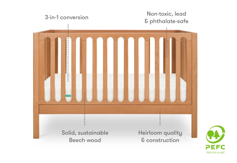 A wooden baby crib featuring 3-in-1 conversion, non-toxic and safe materials, made from solid, sustainable beech wood, with a PEFC certification logo on the right side.