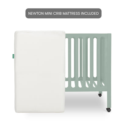The Newton Baby Galileo Mini Crib with Newton Mattress is shown in light green with slatted sides and wheels. A white Newton mini crib mattress stands upright in front. Text above states "NEWTON MINI CRIB MATTRESS INCLUDED.