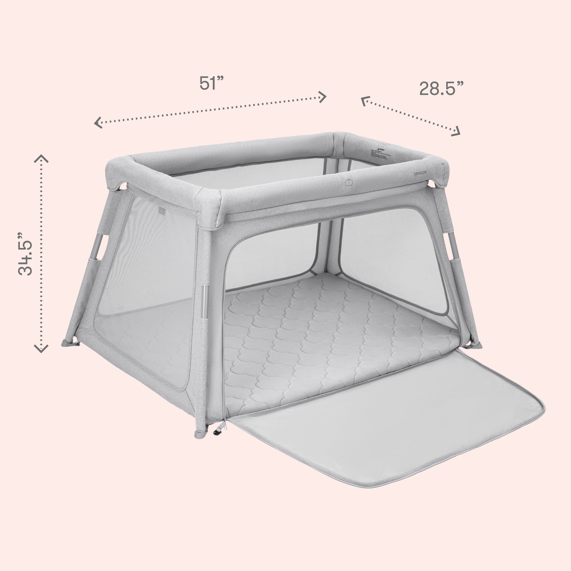 The Newton Baby Deluxe Travel Crib & Play Yard features a rectangular gray design with mesh sides, a zippered flap, and a quilted breathable mattress. Dimensions: 51"W x 28.5"D x 34.5"H. Shown on a pale pink background.