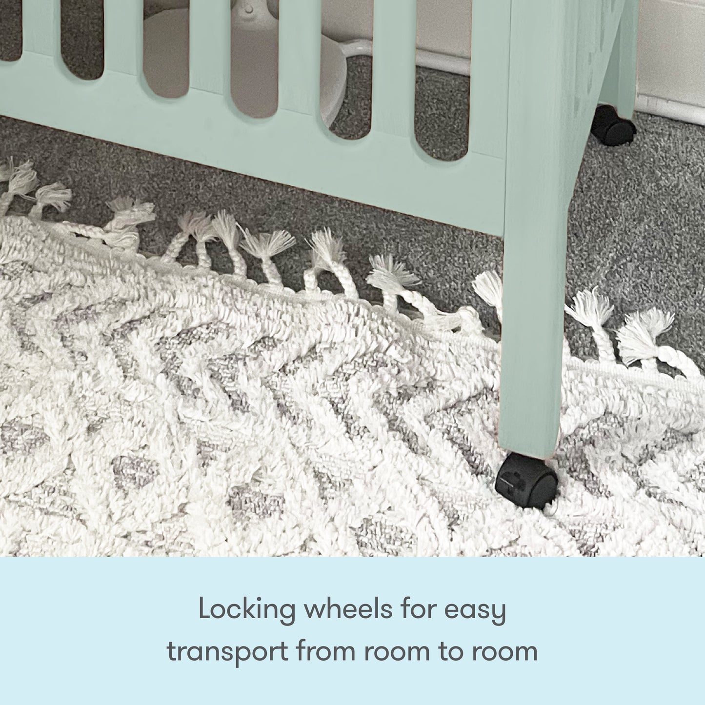 A close-up of a Newton Baby Galileo Mini Crib with Newton Mattress leg shows the black locking wheel on a textured white rug, emphasizing the mobility feature. Text: Locking wheels let you easily move the crib from room to room.
