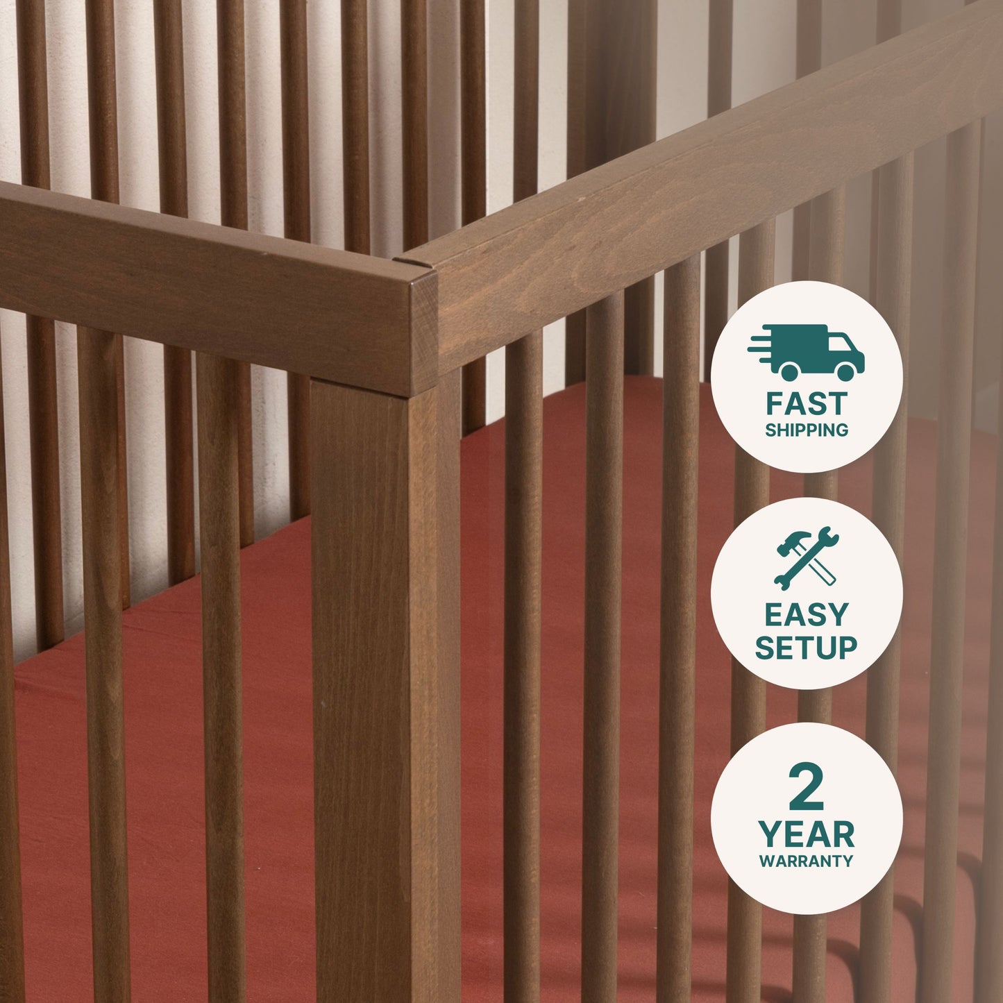 Close-up of the dadada baby Soho Convertible Crib, a mid-century style 3-in-1 crib with vertical slats and a rust-colored mattress. Icons highlight fast shipping, easy setup, and a 2-year warranty.