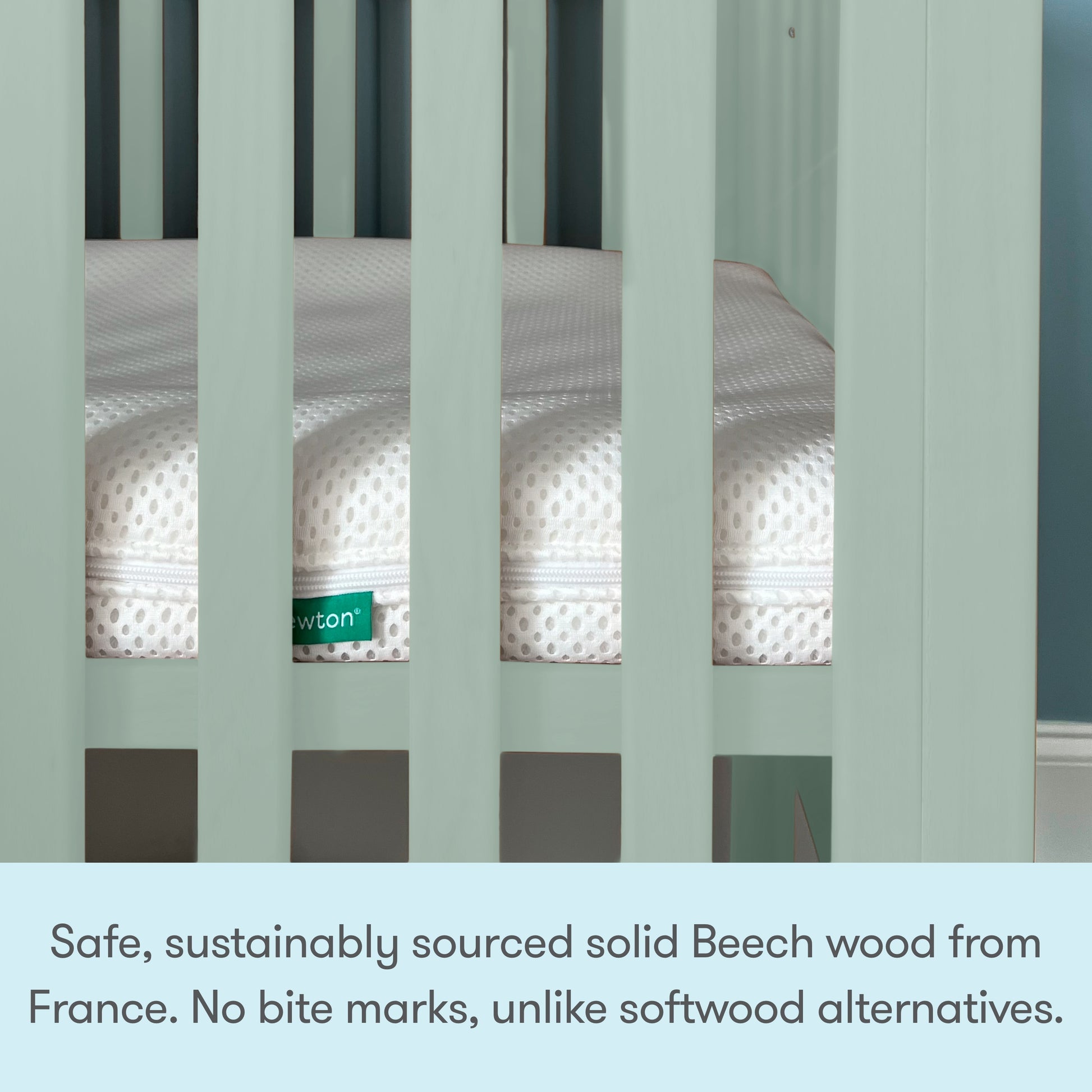 A close-up of the Newton Galileo Mini Crib with Newton Mattress by Newton Baby, featuring light green sustainably sourced French Beech wood, a white mattress inside, portability, and bite mark resistance for your baby’s safety.