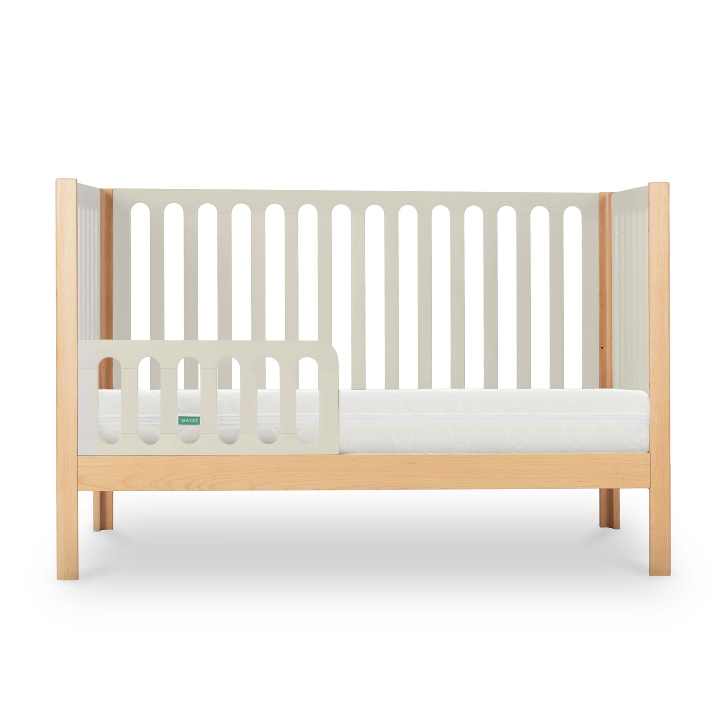 The Newton Baby Newton Galileo Convertible Crib features a light beech wood frame, beige slatted sides, partial safety rail, white mattress, and easily converts from crib to toddler bed with an open side for accessibility.