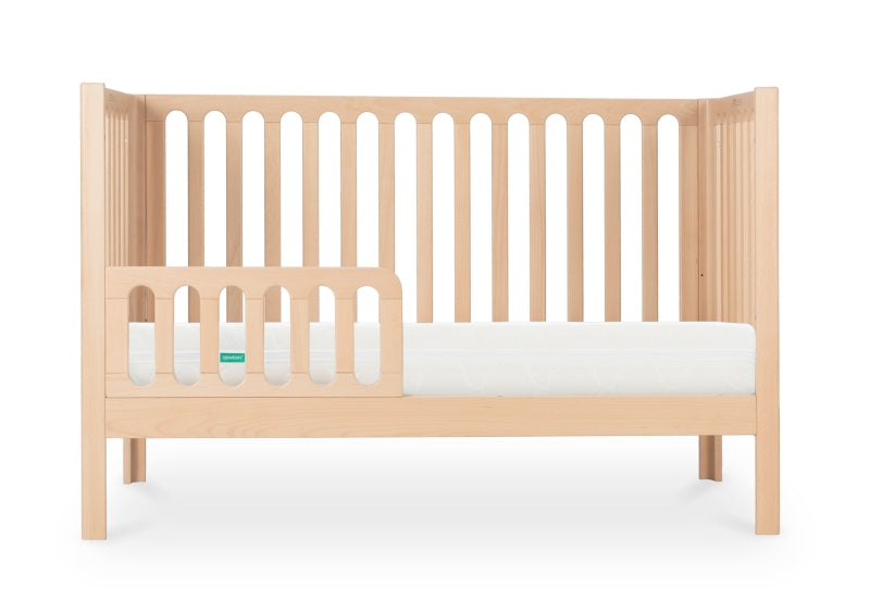A modern wooden baby crib with a Newton mattress, isolated on a white background.