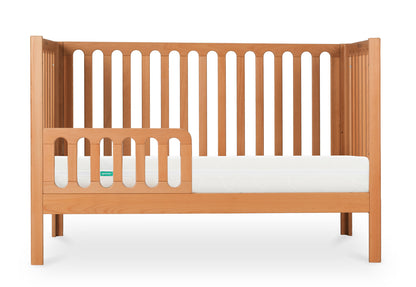 Stylish wooden baby crib featuring a Newton mattress, shown against a white background.