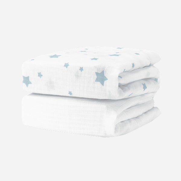 Two Breathable, Organic Cotton Sheets (2-pack) by Newton Baby, featuring a light blue star pattern, are neatly folded and stacked together on a plain white background.