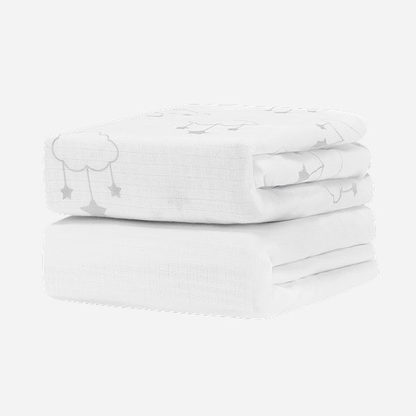 Two Breathable, Organic Cotton Sheets (2-pack) from Newton Baby, featuring a subtle grey cloud and star pattern, are neatly stacked against a plain white background.