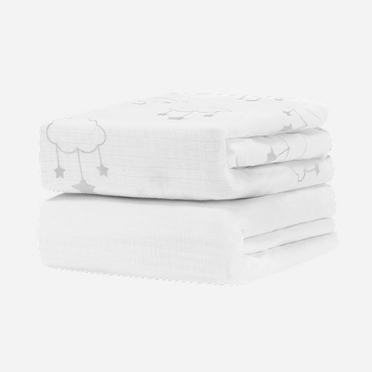 Two Breathable, Organic Cotton Sheets (2-pack) from Newton Baby, featuring a subtle grey cloud and star pattern, are neatly stacked against a plain white background.