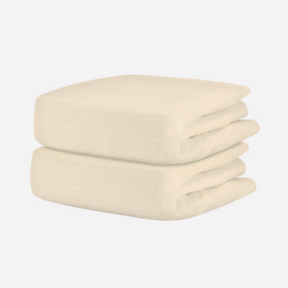 A neatly folded, cream-colored textured blanket pairs beautifully with Newton Baby’s Breathable Organic Cotton Sheets (2-pack), creating a cozy, comfortable nursery.