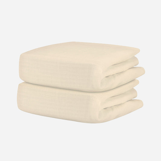 A neatly folded, cream-colored textured blanket pairs beautifully with Newton Baby’s Breathable Organic Cotton Sheets (2-pack), creating a cozy, comfortable nursery.