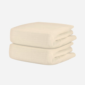 A neatly folded, cream-colored textured blanket pairs beautifully with Newton Baby’s Breathable Organic Cotton Sheets (2-pack), creating a cozy, comfortable nursery.