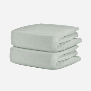 A neatly folded, light gray Breathable, Organic Cotton Sheet from Newton Baby (2-pack) with a subtle textured pattern is displayed against a plain white background.