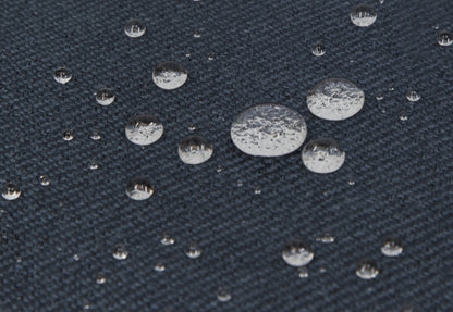 Close-up view of water droplets on a textured dark blue fabric surface.