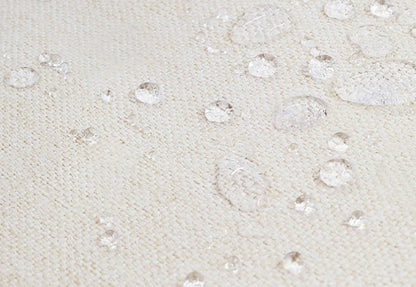 Close-up of a waterproof fabric with droplets of water demonstrating its water-resistant texture.