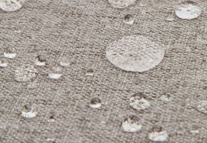 Close-up view of water droplets on a textured gray fabric surface, demonstrating waterproof material.