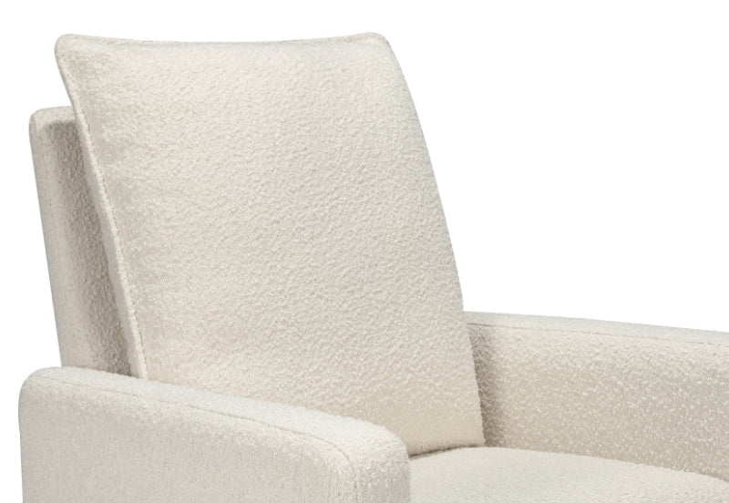 Close-up of a cozy, modern nursery chair with a plush, light beige upholstery.