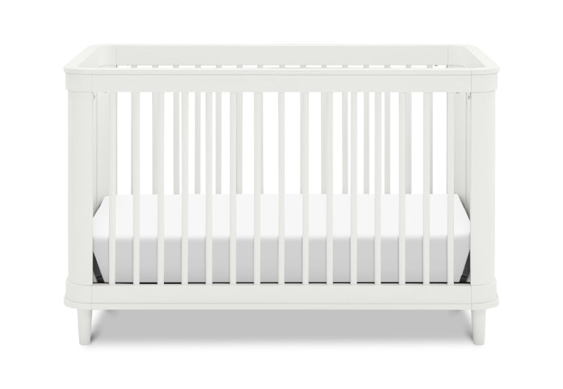 A simple and elegant white baby crib with vertical slats and a solid headboard on a plain background.